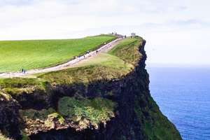Escursionisti che camminano lungo il sentiero costiero pavimentato sul bordo delle Scogliere di Moher nel 2026